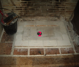 Prise d'air frais venant du sous-sol sous la plaque foyre de l'tre de chemine d'poque.