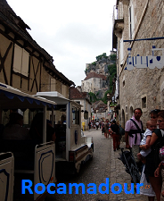 Vous entrez dans la cité par la porte du Figuier avant de suivre la rue de la Couronnerie : l’unique rue de Rocamadour, très animée avec ses boutiques et ses restaurants. Vous parvenez ensuite devant un escalier monumental (233 marches !) qui vous amène au parvis où se pressent sous la roche 8 églises et chapelles. A voir absolument : la chapelle Notre-Dame. Vous y découvrirez la Vierge Noire, frêle silhouette de bois. Enfin, dominant les sanctuaires et le village, le Château dont les remparts se visitent, offre un panorama vertigineux sur la cité. Vous entrez dans la cité par la porte du Figuier avant de suivre la rue de la Couronnerie : l’unique rue de Rocamadour, très animée avec ses boutiques et ses restaurants. Vous parvenez ensuite devant un escalier monumental (233 marches !) qui vous amène au parvis où se pressent sous la roche 8 églises et chapelles. A voir absolument : la chapelle Notre-Dame. Vous y découvrirez la Vierge Noire, frêle silhouette de bois. Enfin, dominant les sanctuaires et le village, le Château dont les remparts se visitent, offre un panorama vertigineux sur la cité.